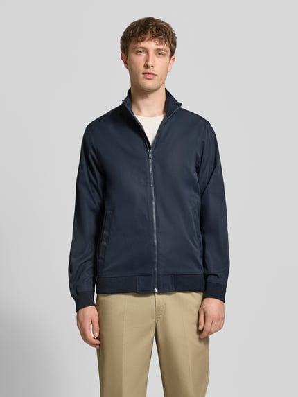 Männermodel trägt Regular Fit Jacke mit Stehkragen Modell 'Hefi' von Blend aus reiner Baumwolle, dunkelblau, Frontansicht, Nahaufnahme Oberkörper.