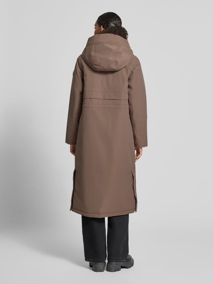 Frauenmodel trägt Regular Fit Parka mit Kapuze Modell 'Melody' von Didriksons in Braun, glatte Textur, aufgesetzte Taschen, Rückansicht Ganzkörperansicht.