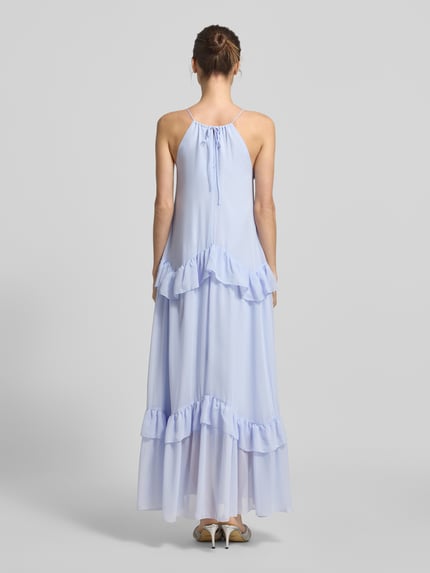 Modelka nosi A-Linie Cocktailkleid mit Unterkleid Modell 'MACKENZIE' od Vero Moda, jasnoniebieska siateczka, jednolity kolor, midi, wysoki dekolt, falbany, tekstura mesh, widok całej sylwetki z tyłu.