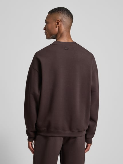 Männermodel trägt Loose Fit Sweatshirt aus Baumwoll-Mix von Lacoste in Optik: Unifarben, Materialverarbeitung: Piqué, Ganzkörperansicht Rückansicht.