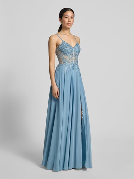 Kobiece model prezentuje długa sukienka „Maxikleid mit Stitchings und Ziersteinbesatz” od Luxuar z szyfonu, taliowany krój, hafty, obszycie ozdobnymi kamieniami, zamek błyskawiczny z tyłu, długość tyłu w rozmiarze 36: 126 cm, szerokość w rozmiarze 36: 41 cm, całkowity widok z przodu.