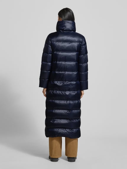 Modelka kobieta nosi granatowy Daunenmantel mit Stehkragen und seitlichen Reißverschlüssen od Lauren Ralph Lauren, pikowana faktura, proste cięcie, długość do połowy łydki, boczne kieszenie, całkowity widok z tyłu.
