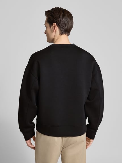 Männermodel trägt schwarzes Sweatshirt mit Rundhalsausschnitt und Logo von CK Calvin Klein, Material-Mix mit Viskose-Anteil, Regular-Fit, Rückenlänge 61 cm, Ärmellänge 59 cm, glatte Textur, Ganzkörperansicht Rückansicht.