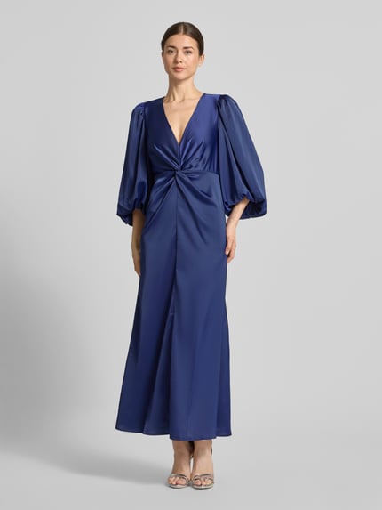 Frauenmodel trägt Maxikleid mit Ballonärmeln Modell 'THEA' von YAS in Blau, Material-Mix mit Stretch-Anteil, taillierter Schnitt, V-Ausschnitt, Knoten-Detail, Ganzkörperansicht von vorne