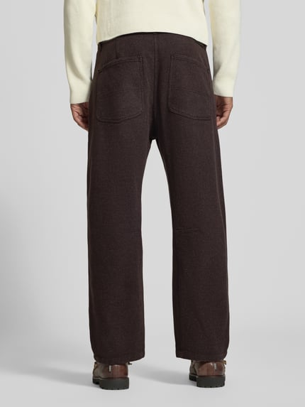Mannenmodel draagt donkerbruine Straight Fit stoffen broek van katoenmix, Model 'GONAGO' van DRYKORN, steekzakken, knoop- en ritssluiting, bandwijdte 45 cm, binnenbeenlengte 69 cm, volledige lichaamsweergave achteraan.