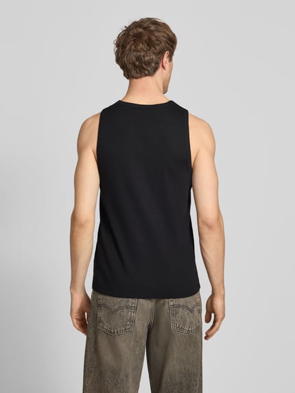 Männermodel trägt Slim Fit Tank Top aus Baumwoll-Mix von Marc O’Polo Denim in Schwarz, Rippstrick, Label Patch, Ganzkörperansicht Rückansicht.