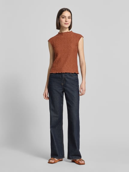 Frauenmodel trägt Top mit Strukturmuster von Jake*s Collection aus Baumwoll-Mix mit Stretch-Anteil, Regular-Fit, Stehkragen, Rückenlänge 53 cm, Farbe Rostrot, kombiniert mit dunkler Jeans, Ganzkörperansicht von vorne.