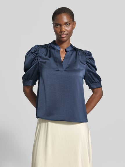 Frauenmodel trägt Regular Fit Bluse aus Satin mit Puffärmeln Modell 'Roella' von Neo Noir in Dunkelblau, V-Ausschnitt, Ganzkörperansicht von vorne.