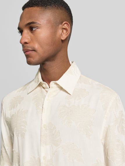 Männermodel trägt Regular Fit Freizeithemd aus Viskose-Mix Modell 'Klampo' von Matinique mit florales Allover-Design, Nahaufnahme Oberkörper.