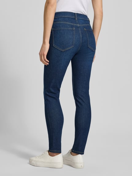 Frauenmodel trägt Slim Fit Jeans im 5-Pocket-Design von Jake*s Casual in Dunkelblau, elastischer Baumwoll-Mix, Ganzkörperansicht Rückansicht.