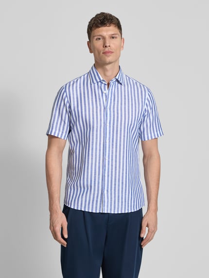 Męski model nosi Slim Fit Business Hemd aus Leinen-Misch mit Kentkragen von Jake*s, niebiesko-białe paski, krój slim fit, mieszanka lnu i bawełny, krótki rękaw, kołnierzyk typu kent, listwa guzikowa, długość tyłu w rozmiarze M: 75 cm, szerokość w rozmiarze M: 43 cm, długość rękawów w rozmiarze M: 25 cm, całkowity widok z przodu