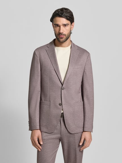 Männermodel trägt Regular Fit Sakko mit Viskose-Anteil Modell 'Manel' von Pierre Cardin in Hellbraun, feine Struktur, Ganzkörperansicht von vorne. Elastischer Material-Mix, Reverskragen, 2-Knopfleiste, Brusttasche, aufgesetzte Taschen, Maße Größe 50.