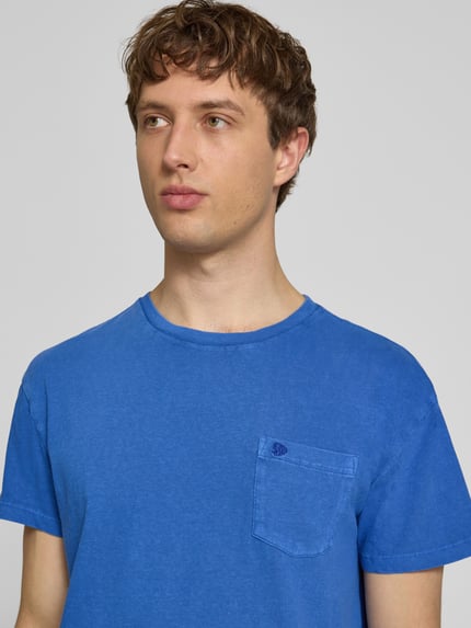 Männermodel trägt T-Shirt aus Baumwoll-Leinen-Mix mit Brusttasche von Superdry in Blau, mit Rundhalsausschnitt, Regular-Fit, Nahaufnahme Oberkörper, Rückenlänge bei Größe M: 66 cm.