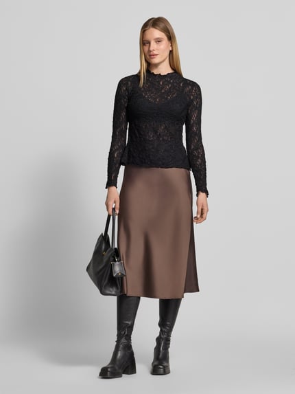 Frauenmodel trägt Langarmshirt mit Ausbrenner-Effekt von s.Oliver BLACK LABEL in Schwarz, kombiniert mit braunem Rock, glatte Textur, Ganzkörperansicht von vorne. Damen Langarmshirt von s.Oliver BLACK LABEL.