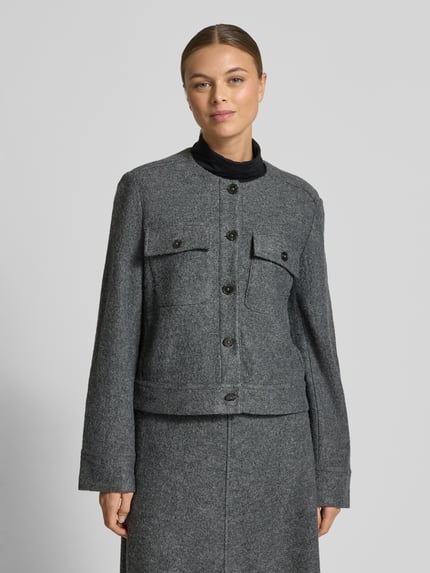 Frauenmodel trägt Taillierter Kurzblazer aus Viskose-Woll-Mix von Marc O'Polo, Optik: Unifarben, Passform: Tailliert, Rundhals, einreihige Knopfleiste, Langarm, Schlitz mit Knopfverschluss, Brusttasche, Material: Viskose-Woll-Mix, dezente graue Farbstruktur, strukturierte Textur, Nahaufnahme Oberkörper.