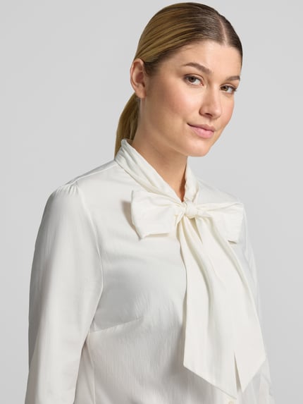 Kobiece modelka nosi Regular Fit Langarmbluse aus Baumwoll-Mix od ROBE LÉGÈRE w kolorze białym, gładka faktura, zbliżenie na górną część ciała