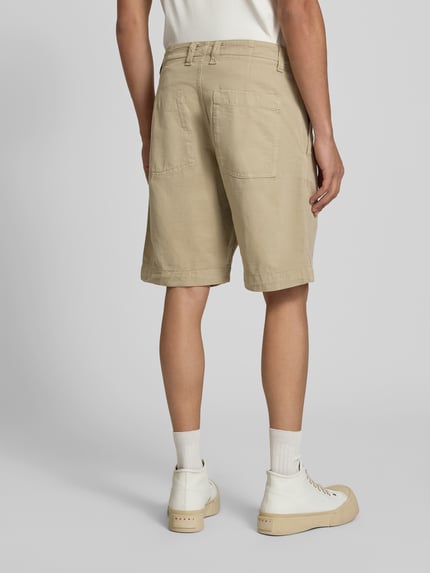 Männermodel trägt Straight Fit Bermuda mit Eingrifftaschen von ANNARR in Beige, Gesäßtaschen, Knielänge, Ganzkörperansicht Rückansicht.