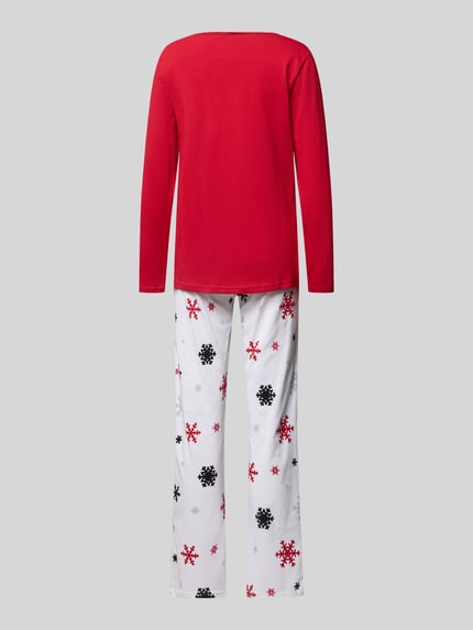 Frauenmodel trägt Pyjama mit Schleifen-Detail Modell 'Winterzauber' von LOUIS & LOUISA, rote Oberteilfarbe, weiße Hose mit Schneeflockenmuster, reine Baumwolle, lockere Passform, Ganzkörperansicht Rückansicht.