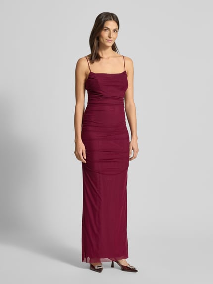 Frauenmodel trägt Slim Fit Abendkleid mit Gehschlitz von Hey Kyla in semitransparentem Mesh, blickdichtem Unterrock, Spaghettiträgern, Nahtreißverschluss, Raffung, in Dunkelrot, Ganzkörperansicht von vorne.