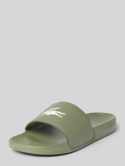 Produktfoto, Badeschuhe mit Logo-Print Modell 'SERVE SLIDE 0.0' von Lacoste, zielona unifarbene optyka, okrągły nosek, płaska podeszwa, struktura, wsuwane