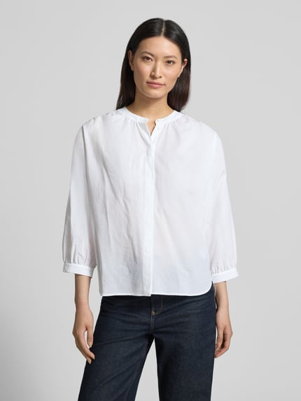 Frauenmodel trägt Bluse mit verdeckter Knopfleiste und verlängertem Rücken von Luisa Cerano in Weiß, reine Baumwolle, lockere Passform, Rundhalsausschnitt, Ganzkörperansicht von vorne.