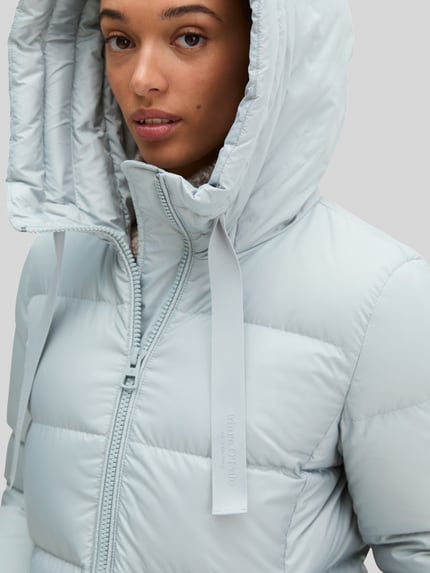 Frauenmodel trägt Regular Fit Daunenmantel mit Label-Print von Marc O'Polo in hellgrau, glatte Struktur, Nahaufnahme Oberkörper, Damen Daunenmantel von Marc O'Polo.