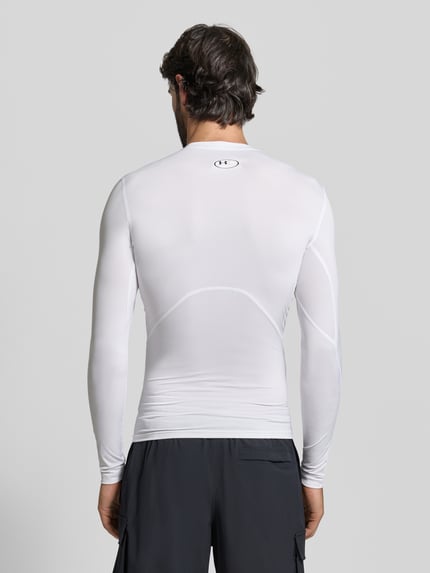 Männermodel trägt Slim Fit Longsleeve mit Logo-Print von Under Armour, elastischer Material-Mix, weiß, Ganzkörperansicht Rückansicht.