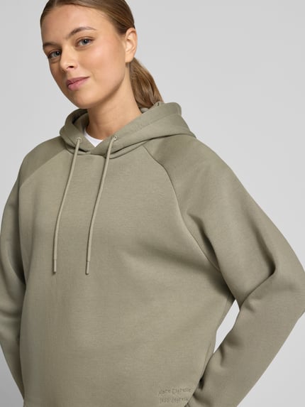 Frauenmodel trägt Hoodie mit Kapuze von Smith and Soul, Baumwoll-Mix, Lockerer-Schnitt, Tunnelzug, Statement-Stitching, Nahaufnahme Oberkörper.