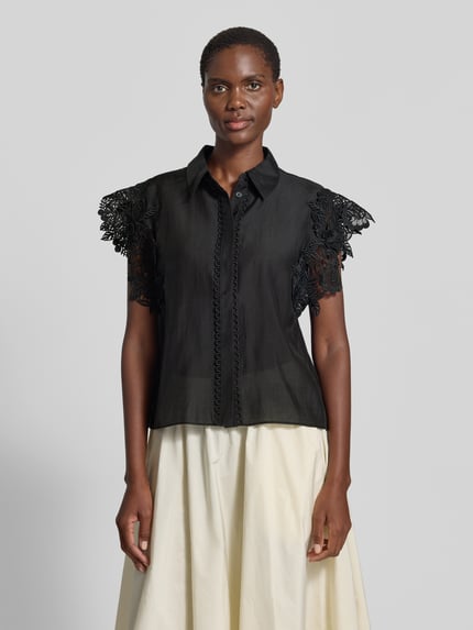 Frauenmodel trägt Regular Fit Bluse mit Spitzenbesatz Modell 'MOLLY' von Copenhagen Muse, Material-Mix mit Stretch-Anteil, Hemdblusenkragen, verdeckte Knopfleiste, Schwarz mit Texturkontrast, Ganzkörperansicht von vorne. Rückenlänge bei Größe S: 62 cm, Ärmellänge bei Größe S: 10 cm.