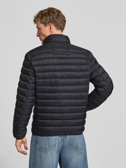 Männermodel trägt schwarze Regular Fit Steppjacke mit Logo-Stickerei von REVIEW, Stepp-Optik, elastische Abschlüsse, Ganzkörperansicht Rückansicht.