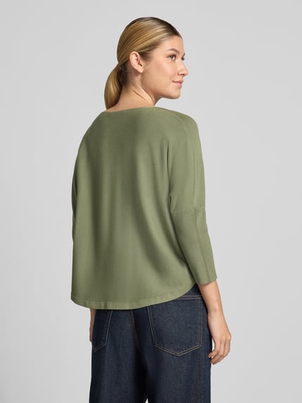 Frauenmodel trägt Strickpullover aus Viskose-Mix Modell 'Tiraja' von someday, olivgrün, strukturierte Oberfläche, entspannte Passform, Ganzkörperansicht Rückansicht.