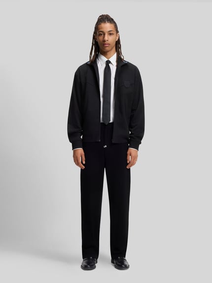 Męski model nosi Slim Fit Freizeithemd aus Baumwoll-Mix Modell 'ERMO' od HUGO, czarna jednolita tkanina, długi rękaw, krój slim fit, widok całej sylwetki z przodu.