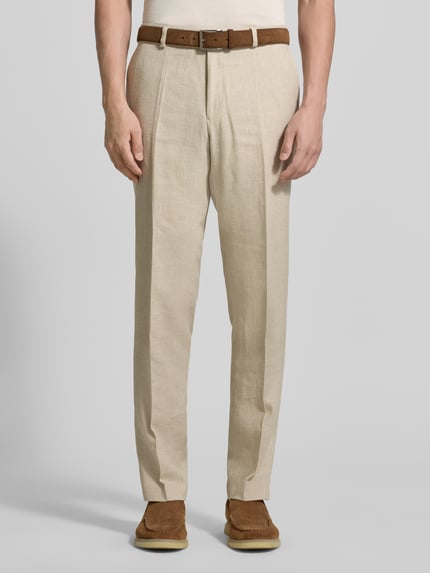 Männermodel trägt Slim Fit Leinenhose mit Woll- und Viskose-Anteil Modell 'Shiver' von Carl Gross, Beige, mit Bügelfalten, Eingriff- und Gesäßtaschen, Knopf- und Reißverschluss, Leinen-Mix, Ganzkörperansicht von vorne. Bundweite bei Größe 50: 45 cm, Innenbeinlänge bei Größe 50: 81 cm.