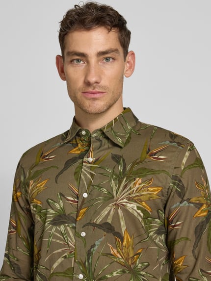 Männermodel trägt Regular Fit Freizeithemd aus Leinen-Baumwoll-Mix mit Kentkragen von MCNEAL, Allover-Look, Nahaufnahme Oberkörper. Rückenlänge 76 cm, Schulterbreite 47 cm, Ärmellänge 66 cm, grüne und braune Farben, glatte Textur.