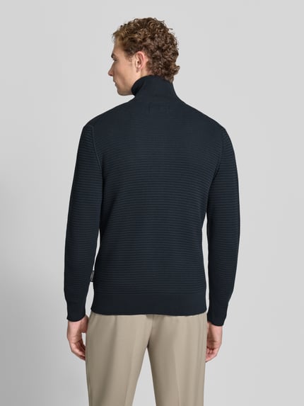 Männermodel trägt Regular Fit Strickjacke aus reiner Baumwolle von Marc O'Polo in Dunkelblau, strukturierte Oberfläche, Ganzkörperansicht Rückansicht, Herren Pullover von Marc O'Polo.