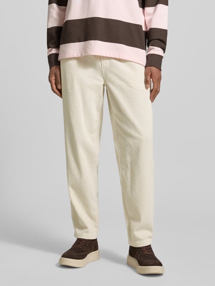 Männermodel trägt Straight Fit Cordhose aus reiner Baumwolle Modell 'Padow' von American Vintage in Creme mit samtartiger Textur, Nahaufnahme Oberkörper. Innenbeinlänge 72 cm, elastischer Bund, Gesäßtaschen.
