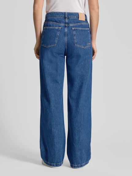 Kobiece modelka nosi Regular Fit Wide Leg Jeans aus reiner Baumwolle Modell 'THE MARLENE' von BOSS Orange, denim, wysoki stan, naszywka z logo, 5 kieszeni, krój regular fit; widok całej sylwetki z tyłu.