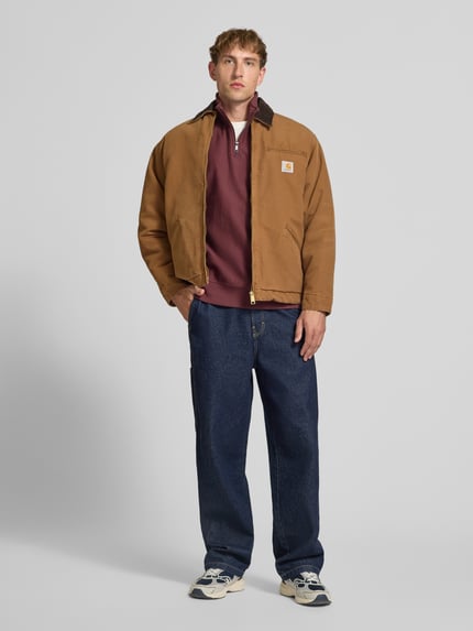 Männermodel trägt Blouson mit Brusttasche Modell 'DETROIT' von Carhartt Work In Progress in Braun, Regular Fit, Ganzkörperansicht von vorne.