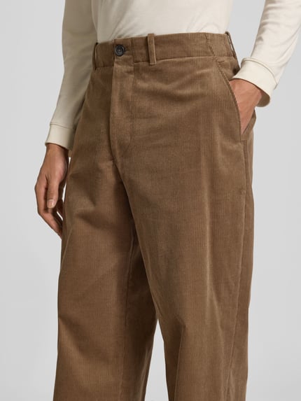 Männermodel trägt Regular Fit Cordhose mit Gürtelschlaufen von ANNARR, braune Struktur, seitliche Taschen, Nahaufnahme Oberkörper.