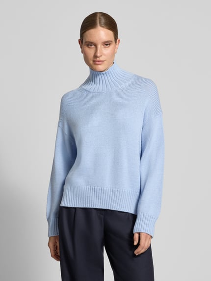 Frauenmodel trägt Strickpullover aus Woll-Mix mit Stehkragen von Closed, hellblau, gerippte Abschlüsse, Loose Fit, Ganzkörperansicht von vorne.