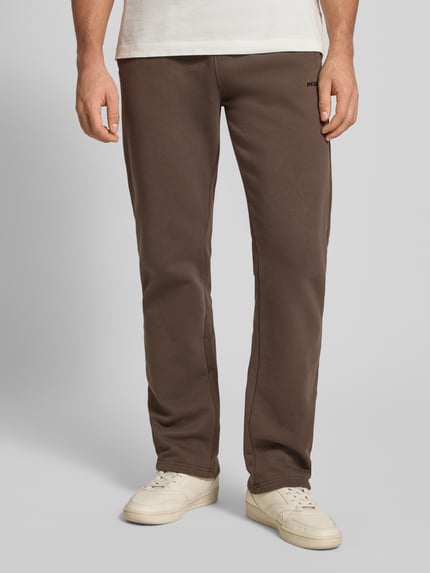 Männermodel trägt Sweathose mit elastischem Bund von Pegador aus Baumwoll-Mix, Lockerer-Schnitt, Label-Stitching, französische Eingrifftaschen, Ganzkörperansicht von vorne.