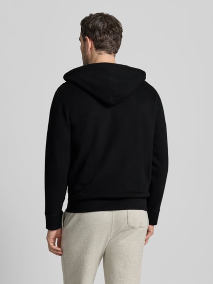 Männermodel draagt Sweatjacke mit Kapuze van Polo Ralph Lauren in zwart, katoenmix, losse pasvorm, geribde boorden, rugaanzicht.
