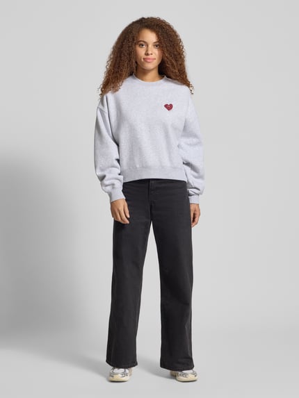 Frauenmodel trägt Sweatshirt mit Motiv-Print Modell 'Nina' von OH APRIL aus Baumwoll-Mix, Relaxed-Fit, Rundhalsausschnitt, Ganzkörperansicht von vorne.