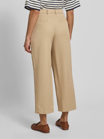 Vrouwenmodel draagt Hose aus Viskose-Baumwoll-Mix mit Gesäßtaschen van WHITE LABEL in beige met relaxed fit, opgestikte plooien, achterzakken, detailopname hele lichaam achteraan.