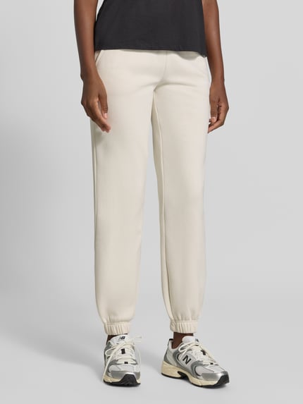 Vrouwenmodel draagt Regular Fit Sweatpants uit katoenmix met labeldetail van aim'n, lichte kleur, elastische boordjes, binnenbeenlengte maat S 78 cm, dames sweatpants, voorkant hele lichaam.