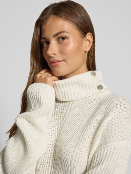 Frauenmodel trägt Strickkleid mit Rollkragen von Liu Jo White im Material-Mix mit Woll-Anteil, feine Rippstruktur, Nahaufnahme Oberkörper.