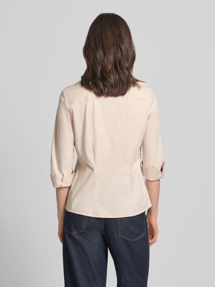 Frauenmodel trägt Hemdbluse mit 3/4-Arm mit Aufschlag von Marc Cain aus Baumwoll-Viskose-Mix, helle Farbe, Ganzkörperansicht Rückansicht.
