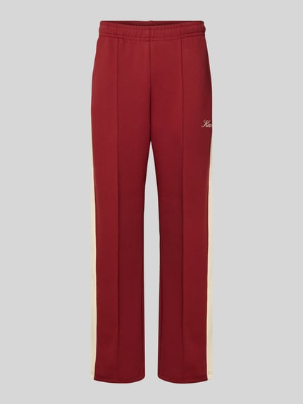 Produktfoto, Sweatpants mit Längsnähten und elastischem Bund von KARL KANI aus Baumwoll-Mix mit Stretch-Anteil, Regular-Fit, Label-Print, bordeauxrot mit beigen Seitenstreifen, glatte Oberfläche, Innenbeinlänge bei Größe M 78 cm.