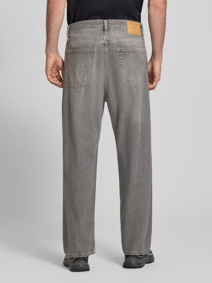 Männermodel trägt Straight Fit Jeans aus reiner Baumwolle im Used-Look von JACK & JONES in Grau mit 5-Pocket-Design, Ganzkörperansicht Rückansicht.