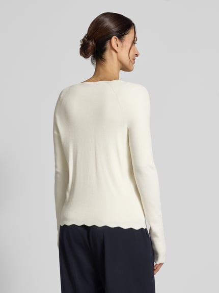 Vrouwenmodel draagt Strickcardigan aus Viskose-Mix van Christian Berg Woman in ecru met ruches, getailleerd model, knoopsluiting, v-hals, ruglengte 55 cm, mouwlengte 50 cm, ganzlichaamsaanzicht achteraan.
